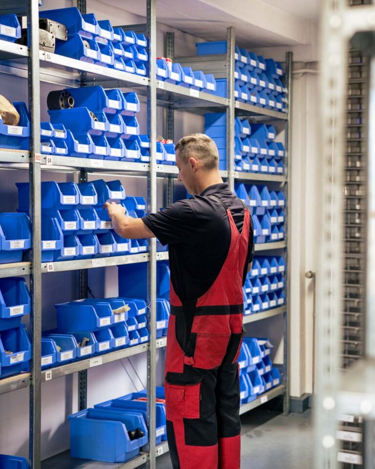 Ersatzteillager von HK Hydraulik – ein Mitarbeiter steht vor dem Regal
