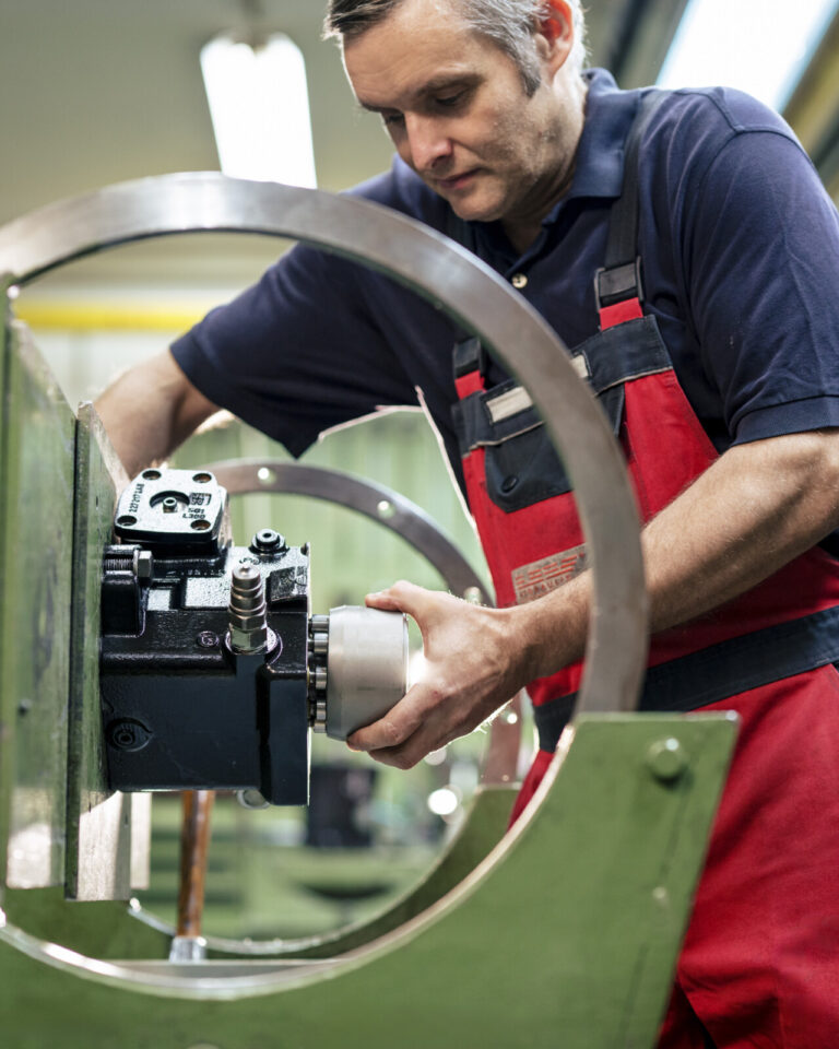 HK Hydraulik Mitarbeiter prüft eine Hydraulik-Komponente