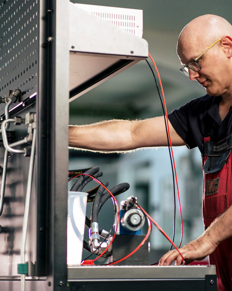 HK Hydraulik Mitarbeiter repariert eine Hydraulik Komponente